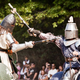 Two knights riding horses at a Renaissance Faire.